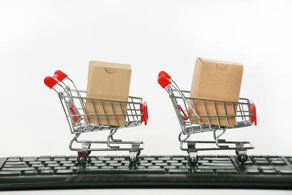 shopping carts with boxes on computer keyboard white background