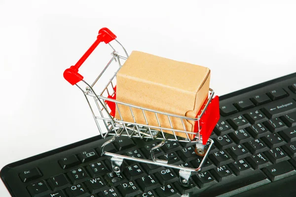 shopping carts with boxes on computer keyboard white background