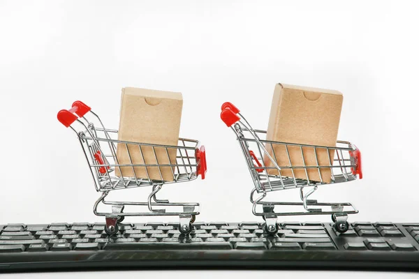 shopping carts with boxes on computer keyboard white background