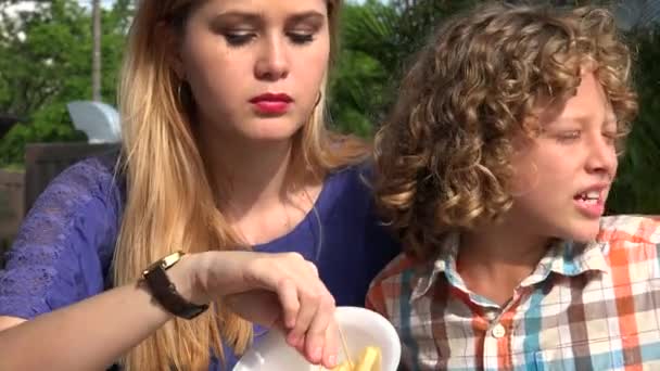 Menino e adolescente menina comer almoço — Vídeo de Stock