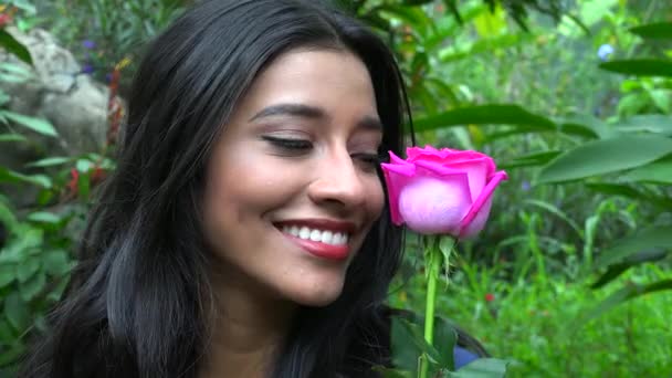 Lächelnde hispanische Frau mit rosa Blume — Stockvideo