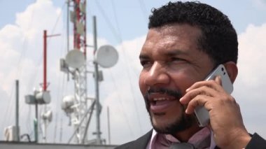 Baz istasyonu yakınındaki cep telefonuyla konuşan adam