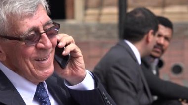 Mutlu üst düzey yönetici cep telefonuyla konuşuyor