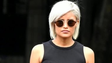 Ciddi genç kadın güneş gözlüğü takıyor söz