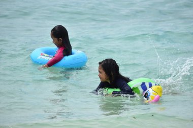 Çeşitli Asyalılar Okyanusta Eğleniyor