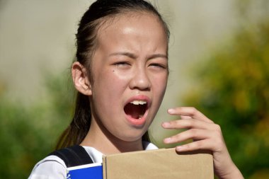 Ders kitaplarıyla üşütmüş şirin Filipinli kız öğrenci.