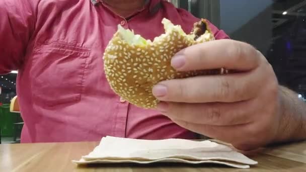 Um homem comendo hiperlapso hambúrguer — Vídeo de Stock