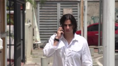 Adam cep telefonuyla konuşuyor.