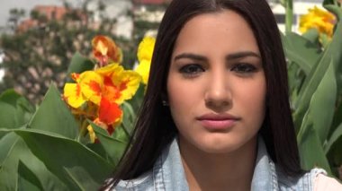 Çiçeklerin yanında poz veren genç kadın