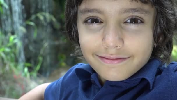 Предподростковий латиноамериканського хлопчик посміхаючись в природі — стокове відео