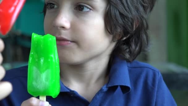 Junge isst grünes Eis am Stiel — Stockvideo