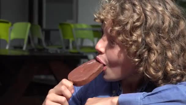 Giovane ragazzo mangiare gelato al cioccolato — Video Stock