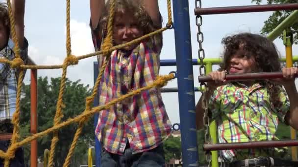 Мальчики карабкаются на канатах на детской площадке — стоковое видео