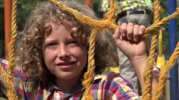 Gelukkige jongen op speelplaats in de zomer — Stockvideo