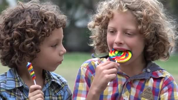 Irmãos comendo pirulito doce — Vídeo de Stock