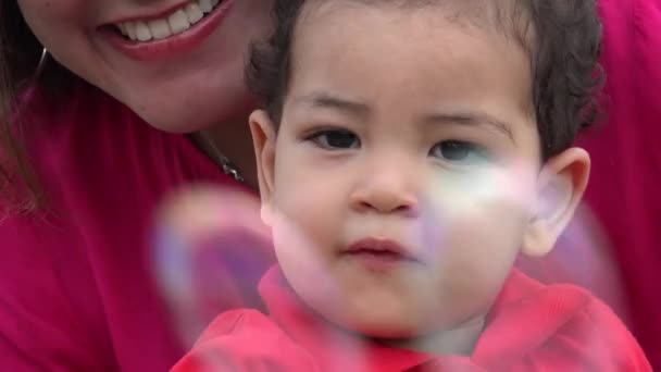 Bebé curioso sonriendo cerca de burbujas — Vídeo de stock