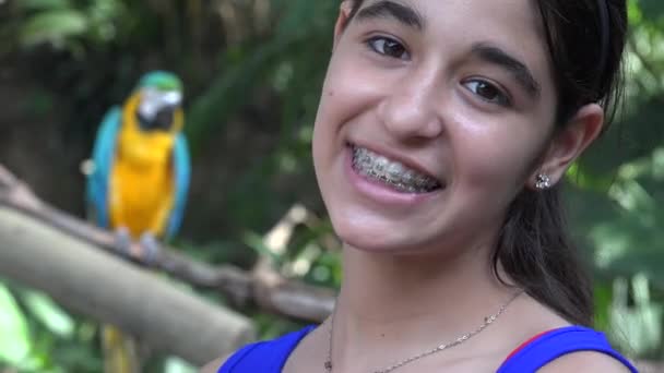 Девушка-подросток улыбается попугаю — стоковое видео