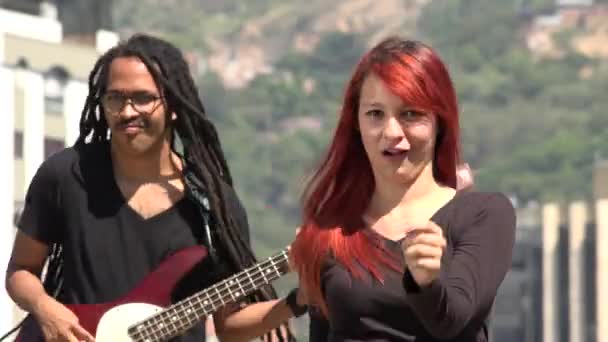 Rödhårig tonåring kvinna dansar med gitarristen — Stockvideo