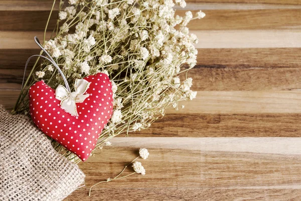 Corazón de tela y flores secas sobre fondo de madera — Foto de Stock