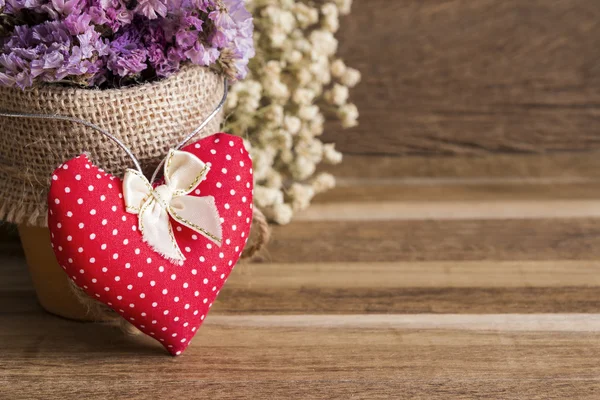 Heart fabric and dry flowers on wooden background — Stock Photo, Image