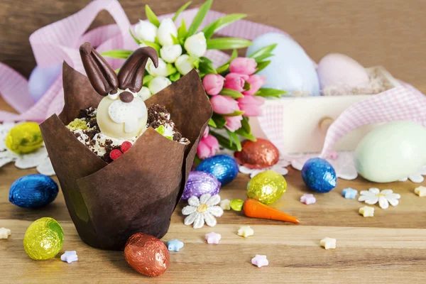 Easter cupcake and chocolate eggs on wooden background — Stock Photo, Image