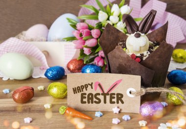 Mutlu Paskalya dekorasyon ahşap arka plan üzerinde kek ve çikolata yumurta