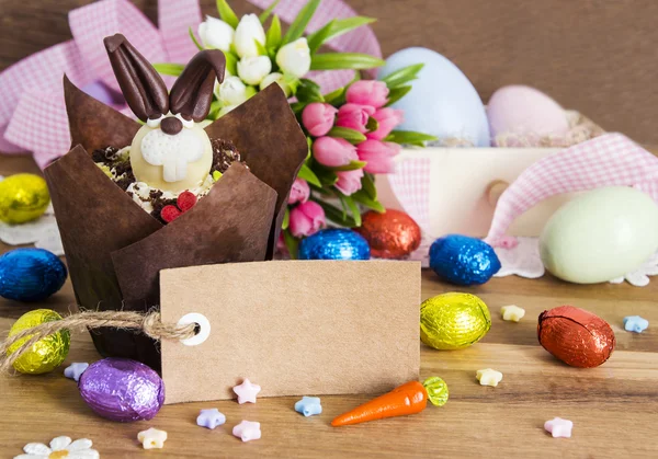 Etiqueta de papel em branco e cupcake de Páscoa no fundo de madeira — Fotografia de Stock