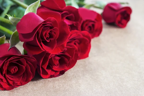 Rosas vermelhas sobre papel castanho — Fotografia de Stock
