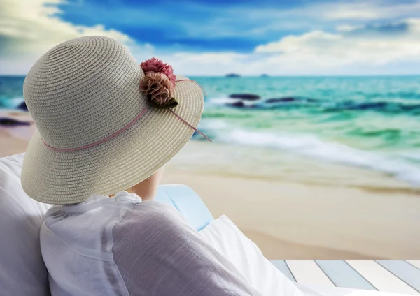 Mujer joven relajante y buscando mar en la cama en la playa — Foto de Stock