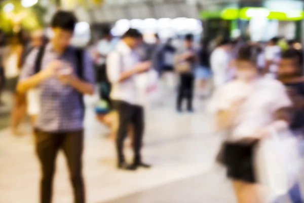 Abstracto fondo borroso de las personas que utilizan el teléfono móvil en el —  Fotos de Stock