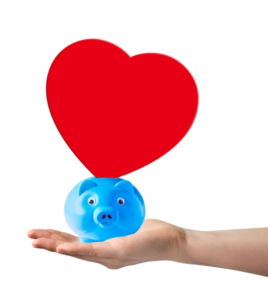 Piggy bank with red paper shape heart on hand — Stock Photo, Image