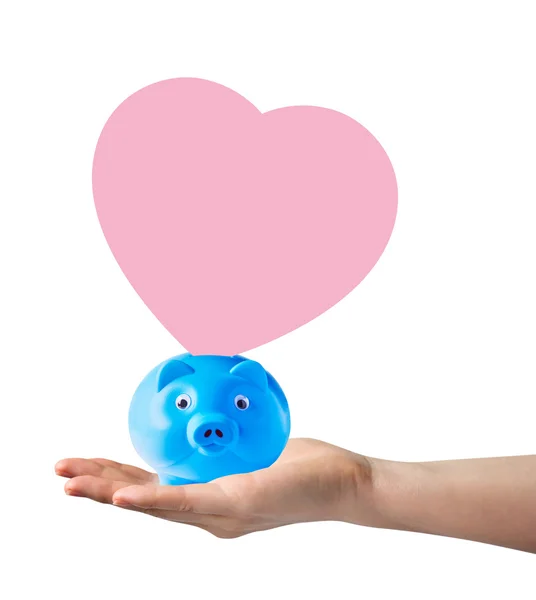 Piggy bank with pink paper shape heart on hand — Stock Photo, Image