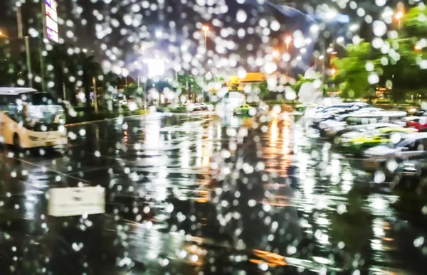 Blur achtergrond van parkeerplaats op een regenachtige avond — Stockfoto