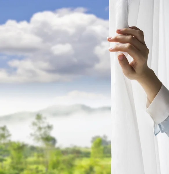 Young woman opening curtains in bedroom — Stock Photo, Image