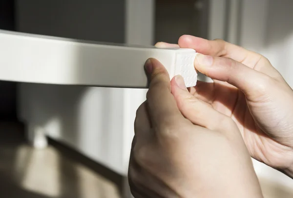 Junge Frau klebt Bodenpflegekissen an Stuhlbeinen — Stockfoto