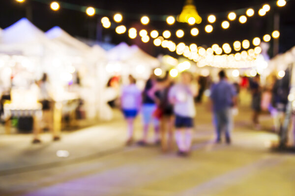 Абстрактный размытый фон людей, совершающих покупки на ночном рынке
