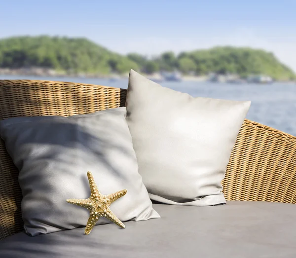 Almohada y estrella de mar con sombra de árbol en sofá de tejido — Foto de Stock