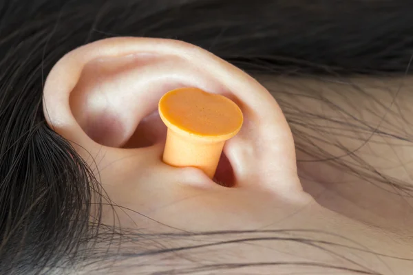 Young woman with earplugs sleeping on the bed Royalty Free Stock Photos