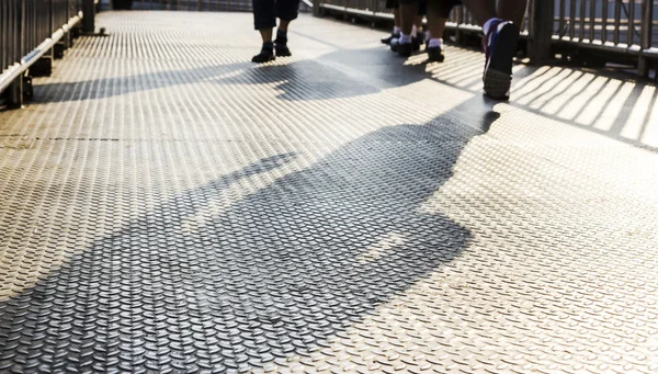 Stíny lidí, kteří jdou na ocelové nadjezdu — Stock fotografie