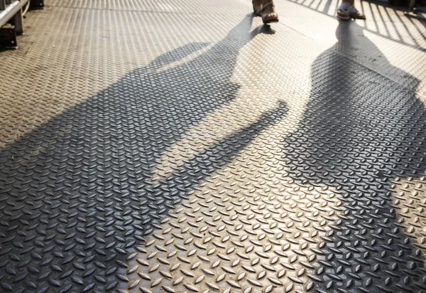 Sombras de pessoas andando no viaduto de aço — Fotografia de Stock