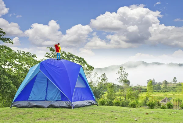 Miniatuur backpacker op blauwe tent bij berg — Stockfoto