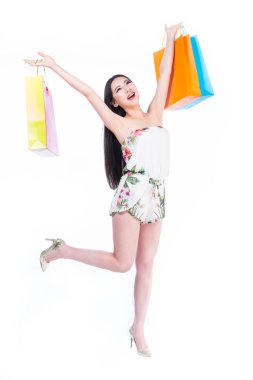 Beyaz arka planda alışveriş torbaları olan genç bir kadın.