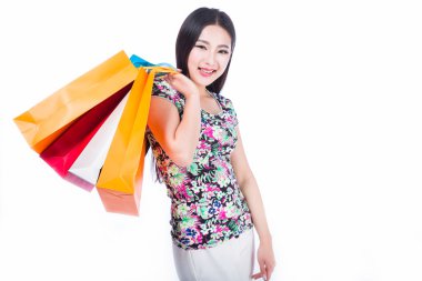 Beyaz arka planda alışveriş torbaları olan genç bir kadın.