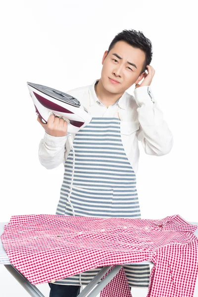 Chinese young man ironing his clothes — Stock Photo, Image