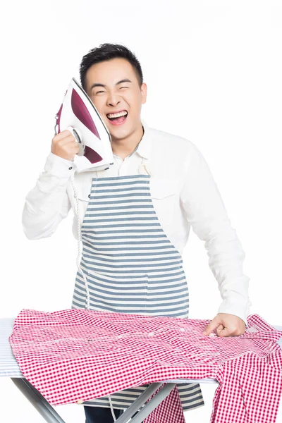 Čínský mladík žehlení oblečení — Stock fotografie