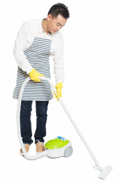 Young man uses vacuum cleaner — Stock Photo, Image