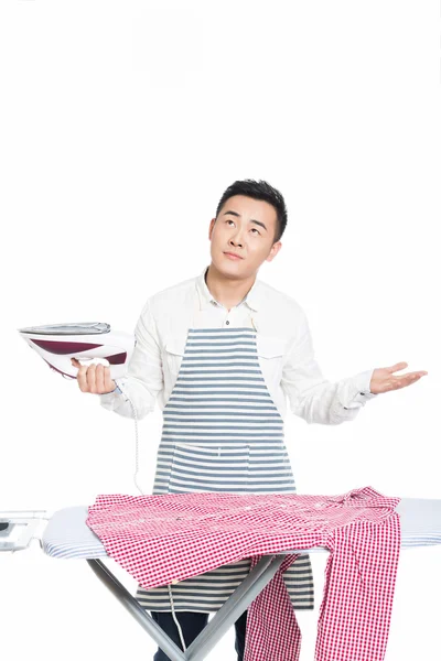 Chinese young man ironing his clothes — Stock Photo, Image