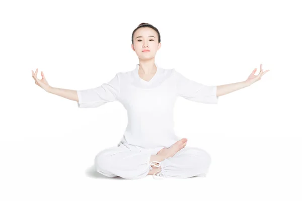 Mujer sentada en el suelo ejerciendo yoga — Foto de Stock