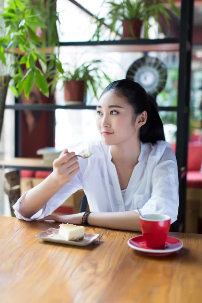 Menina comer um bolo no café — Fotografia de Stock