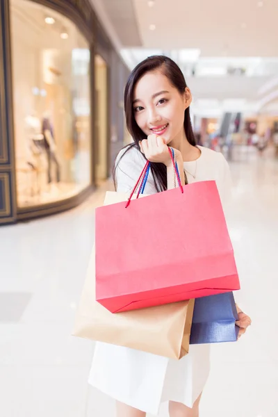 Portrait young adult girl with colored bags — Stock Photo, Image